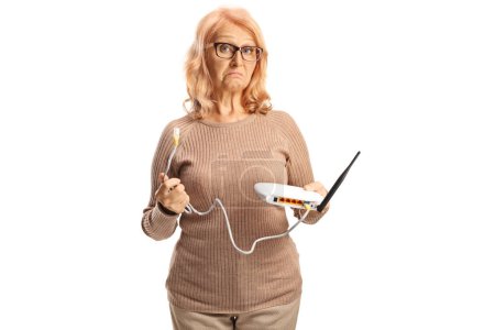 Photo for Mature woman holding a router with a connection cable isolated on white background - Royalty Free Image