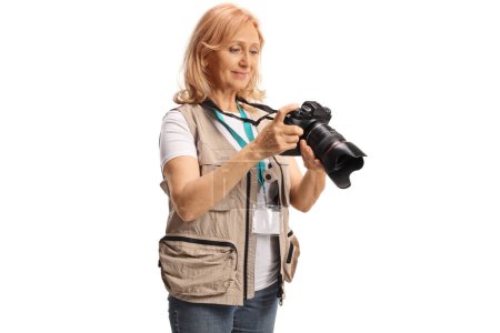 Téléchargez les photos : Femme photographe regardant un écran de caméra isolé sur fond blanc - en image libre de droit
