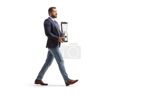 Photo for Full length profile shot of a man carrying a food processor isolated on white background - Royalty Free Image