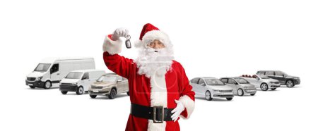 Photo for Santa claus holding a key in front of cars isolated on white background - Royalty Free Image