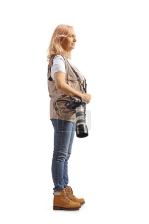 Téléchargez les photos : Spectacle de profil complet d'une photographe féminine avec une caméra sur bandoulière isolée sur fond blanc - en image libre de droit