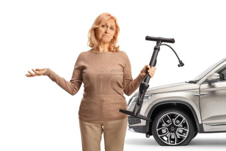 Téléchargez les photos : Femme avec un 4x4 et un pneu crevé tenant une pompe manuelle isolée sur fond blanc - en image libre de droit