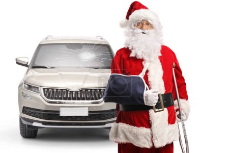 Photo for Santa claus with injured arm leaning on a crutch after a car accident isolated on white background - Royalty Free Image