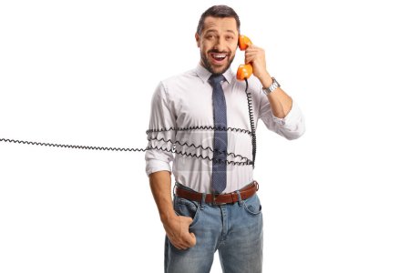 Photo for Man tied with a rotary phone cable, having a conversation and smiling isolated on white background - Royalty Free Image
