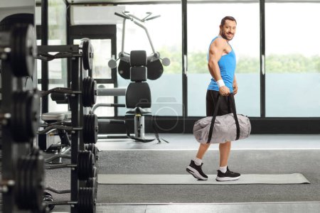 Foto de Hombre con una bolsa de deporte caminando dentro de un gimnasio - Imagen libre de derechos