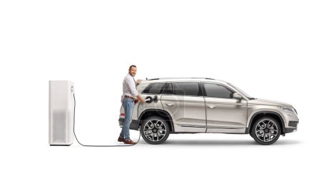 Téléchargez les photos : Propriétaire d'une voiture électrique à un point de charge isolé sur fond blanc - en image libre de droit