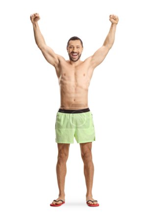 Téléchargez les photos : Portrait complet d'un homme excité en maillot de bain levant les bras isolé sur fond blanc - en image libre de droit