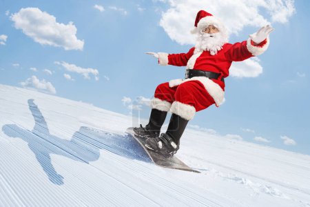 Foto de Santa Claus montando una tabla de snowboard en una montaña - Imagen libre de derechos
