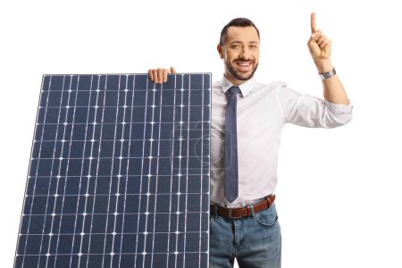 Foto de Hombre profesional detrás de un panel solar apuntando hacia arriba aislado sobre fondo blanco - Imagen libre de derechos