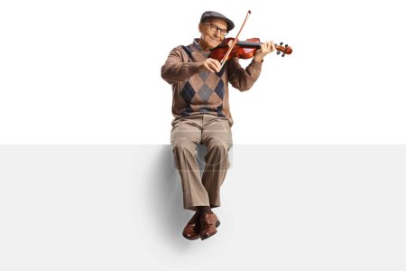 Photo for Elderly man sitting on a panel playing a violin and smiling isolated on white background - Royalty Free Image