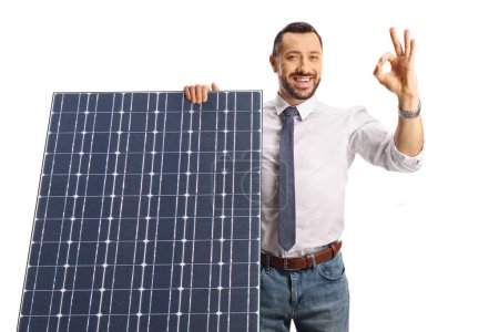 Foto de Hombre profesional detrás de un panel solar gesto ok signo aislado sobre fondo blanco - Imagen libre de derechos