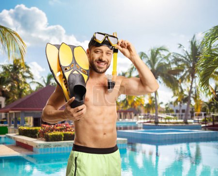 Foto de Hombre en traje de baño con una máscara y aletas de snorkel de pie junto a una piscina - Imagen libre de derechos