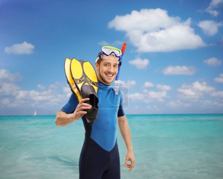 Foto de Chico en traje de neopreno con equipo de snorkel en el mar - Imagen libre de derechos