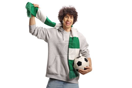 Foto de Joven feliz animando con una bufanda verde y blanca sosteniendo un fútbol aislado sobre fondo blanco - Imagen libre de derechos