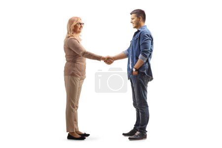 Foto de Plano de perfil de longitud completa de la mujer de mediana edad y un hombre más joven estrechando las manos aisladas sobre fondo blanco - Imagen libre de derechos