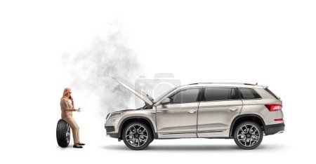 Téléchargez les photos : Femme avec une voiture en panne assise sur un pneu et appelant la compagnie d'assistance routière isolée sur fond blanc - en image libre de droit