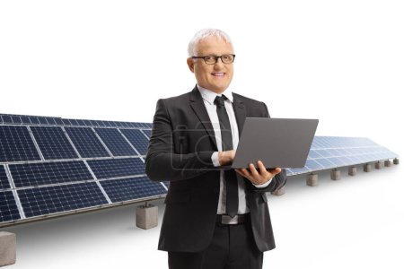 Photo for Mature professional man with a laptop in front of solar panels isolated on white background - Royalty Free Image