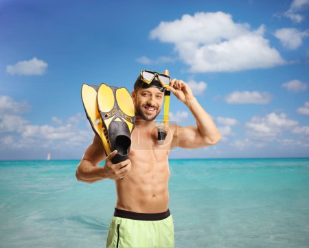 Photo for Man in swimwear with a mask and snorkeling fins in front of a sea on Cuba - Royalty Free Image
