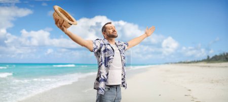 Téléchargez les photos : Joyeux jeune homme profitant de la brise de la mer sur une plage à Cuba - en image libre de droit