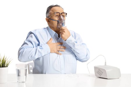 Foto de Hombre maduro con problemas en el pecho usando un nebulizador aislado sobre fondo blanco - Imagen libre de derechos