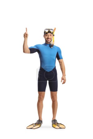 Téléchargez les photos : Homme portant une combinaison de plongée, un masque et des nageoires pointant vers le haut isolé sur fond blanc - en image libre de droit