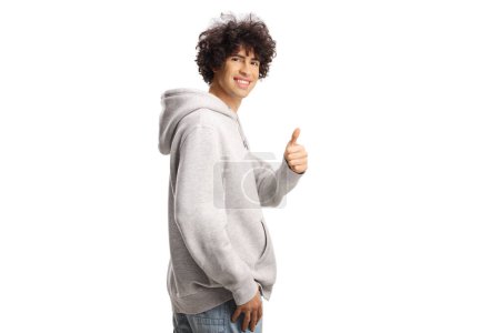 Photo for Guy with curly hair in a gray hoodie gesturing thumbs up isolated on white background - Royalty Free Image