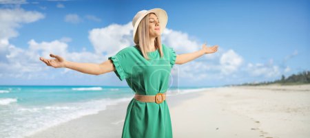 Téléchargez les photos : Jeune femme aux yeux fermés jouissant sur une plage au bord de la mer - en image libre de droit