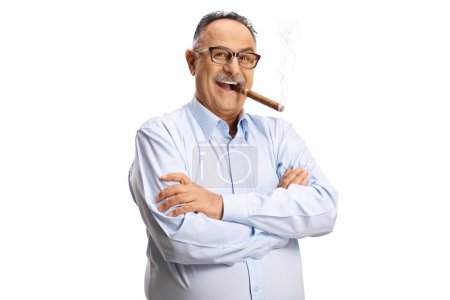 Téléchargez les photos : Homme mûr fumant un cigare et posant avec les bras croisés isolés sur fond blanc - en image libre de droit