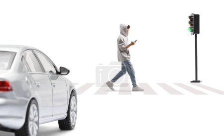 Photo for Gen z guy wearing a gray hoodie and walking with a smartphone in front of a car isolated on white background - Royalty Free Image