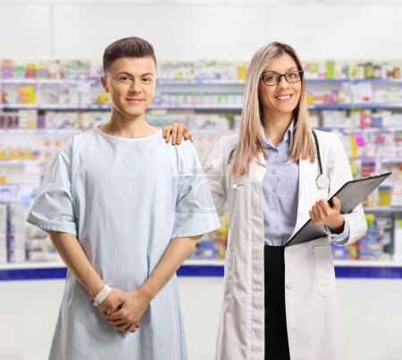 Téléchargez les photos : Médecin féminin et un jeune patient masculin debout dans une pharmacie - en image libre de droit