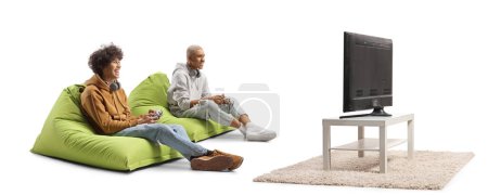 Foto de Amigos sentados en bolsas de frijoles y jugando videojuegos con joysticks frente a la televisión aislados sobre fondo blanco - Imagen libre de derechos