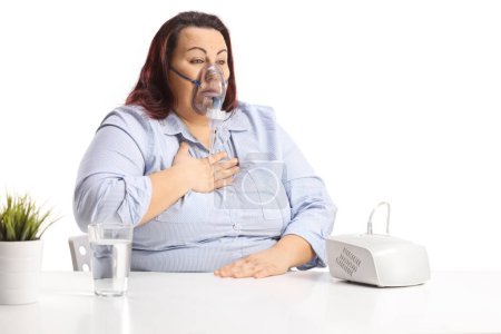 Photo for Woman holding her chest and using a nebulizer isolated on white background - Royalty Free Image
