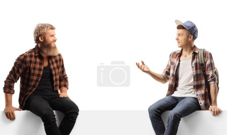 Photo for Student sitting on a blank panel and talking to a bearded guy isolated on white background - Royalty Free Image