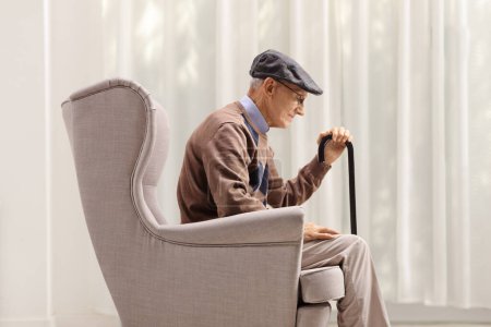 Téléchargez les photos : Triste vieillard solitaire assis dans un fauteuil - en image libre de droit
