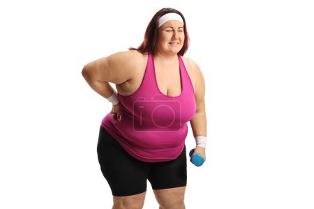 Téléchargez les photos : Femme en vêtements de sport avec un problème de poids tenant son dos douloureux isolé sur fond blanc - en image libre de droit