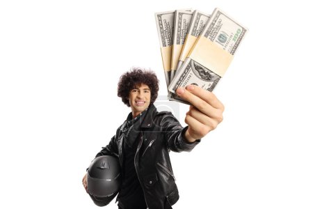 Photo for Guy in a black leather jacket holding a helmet and stacks of money isolated on white background - Royalty Free Image