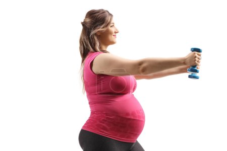 Photo for Profile shot of a pregnant woman exercising with blue dumbbells isolated on white background - Royalty Free Image