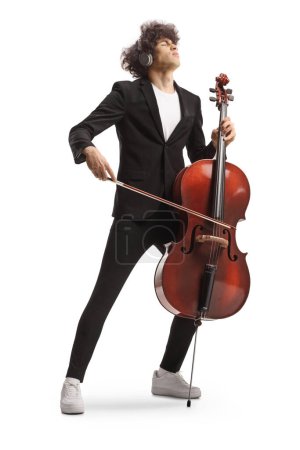 Téléchargez les photos : Portrait complet d'un artiste masculin avec écouteurs jouant un violoncelle isolé sur fond blanc - en image libre de droit