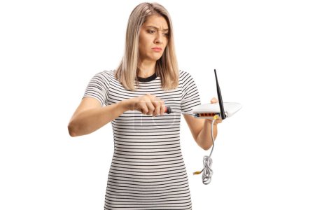 Foto de Confused young woman fixing a router isolated on white background - Imagen libre de derechos
