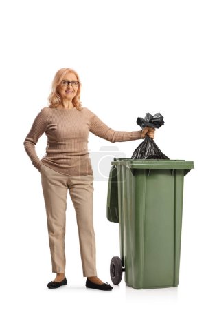 Téléchargez les photos : Woman throwing a plastic waste bag in a bin isolated on white background - en image libre de droit