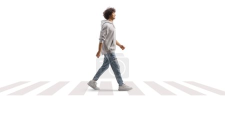 Photo for Full length portrait of a tall guy with curly hair walking at a pedestrian crossing isolated on white background - Royalty Free Image