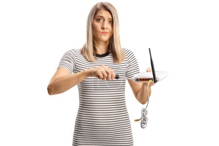 Téléchargez les photos : Grincheuse jeune femme fixant un routeur isolé sur fond blanc - en image libre de droit