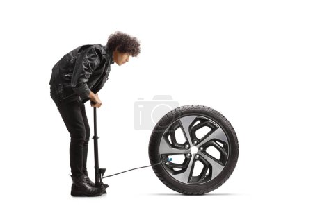 Téléchargez les photos : Jeune homme pompage un pneu de voiture isolé sur fond blanc - en image libre de droit