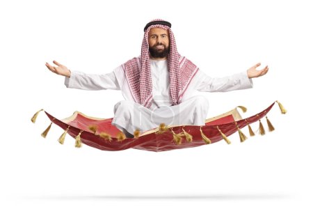 Photo for Saudi arab man floating on a magic carpet isolated on white background - Royalty Free Image