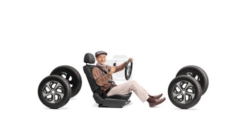 Téléchargez les photos : Homme âgé joyeux dans un siège d'auto tenant une clé et un volant isolé sur fond blanc - en image libre de droit