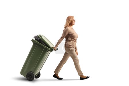 Téléchargez les photos : Femme marchant et tirant une poubelle isolée sur fond blanc - en image libre de droit