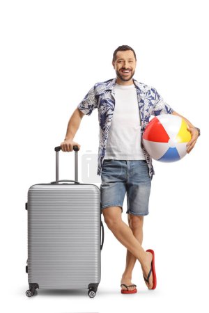 Photo for Man with a suitcase smiling and holding a beach ball isolated on white background - Royalty Free Image