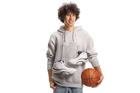 Foto de Chico llevando zapatos de baloncesto alrededor del cuello y una pelota aislada sobre fondo blanco - Imagen libre de derechos