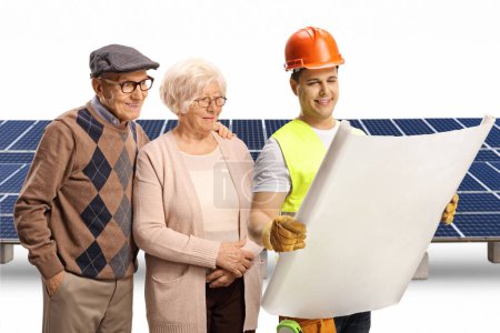 Téléchargez les photos : Travailleur de la construction et un couple âgé regardant un plan photovoltaïque isolé sur fond blanc - en image libre de droit