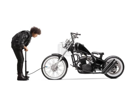 Foto de Foto de perfil completo de un joven bombeando un neumático de moto plano aislado sobre fondo blanco - Imagen libre de derechos